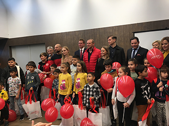 Ünneplő gyermekek lufikkal és ajándékcsomagokkal