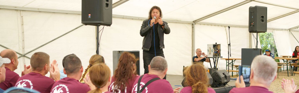 Hevesi Tamás énekel a fotón egy postai rendezvényen