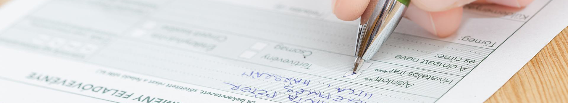 A képen egy ajánlott szelvényt kitöltő kéz látható.